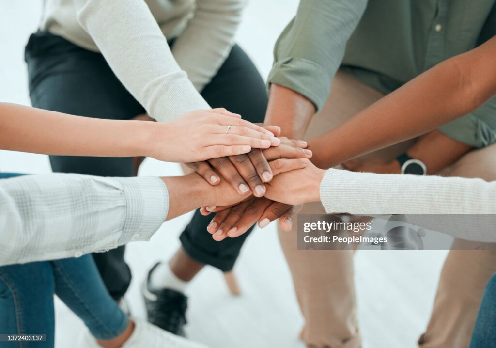 A rather cheesy stock photo of people of different races placing their hands together
